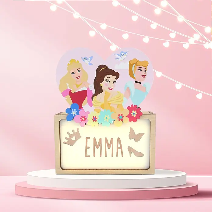 Lámpara de sobremesa infantil Princesas Disney - 0,5 W, L x An x Al: 5 x 12,5 x 17 cm, Luz nocturna, Princesas - Caja de luz de madera personalizada para Emma, con princesas Disney, flores de colores, corona, mariposa y zapato. Expuesta sobre un pedestal.