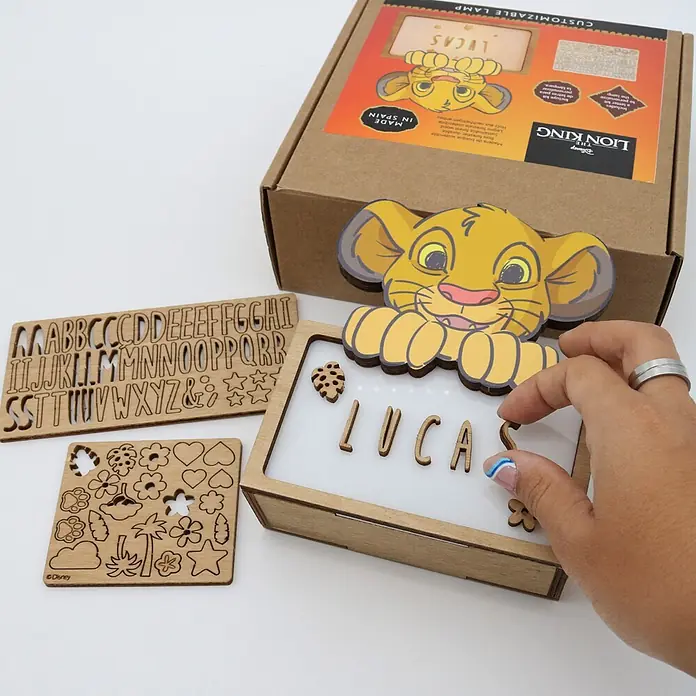 Lámpara de sobremesa infantil Simba - 0,5 W, L x An x Al: 5 x 12,5 x 17 cm, Luz nocturna, Simba - Una lámpara personalizable de madera del Rey León con una mano colocando letras de madera para 'LUCA' en su panel blanco. Incluye letras y formas de madera.