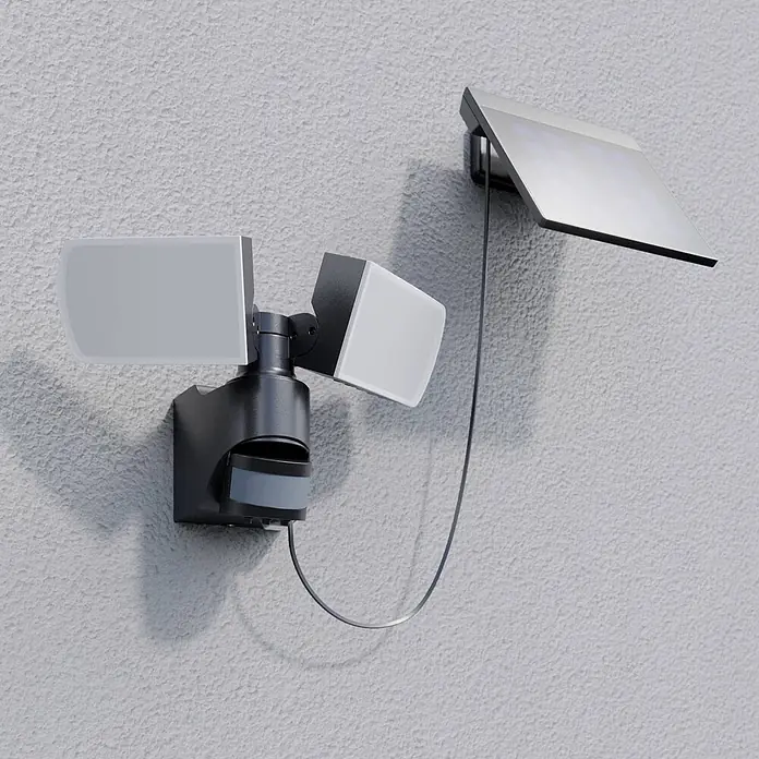 Arcchio Außenwandleuchte Lissano - schwarz, IP44 - Schwarzer solarbetriebener Bewegungsmelder-Strahler mit zwei verstellbaren Lampen und separatem Solarpanel, an der Wand montiert.