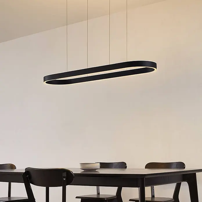 Lucande Pendelleuchte Melinay - L x B x H: 110 x 32 x 4,5 cm, schwarz, Schwarz - Moderne schwarze ovale LED-Pendelleuchte über einem dunklen Esstisch.