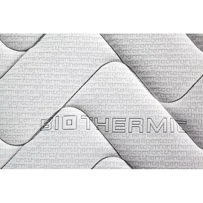 Nonnos Bedding Colchón Visco Plus - Largo: 190 cm, Ancho: 80 cm, Altura: 24 cm, Viscoelástica - Primer plano de un tejido acolchado blanco con texto en relieve "BIOTHERM" y patrón repetitivo "comfortthermalintelligent".