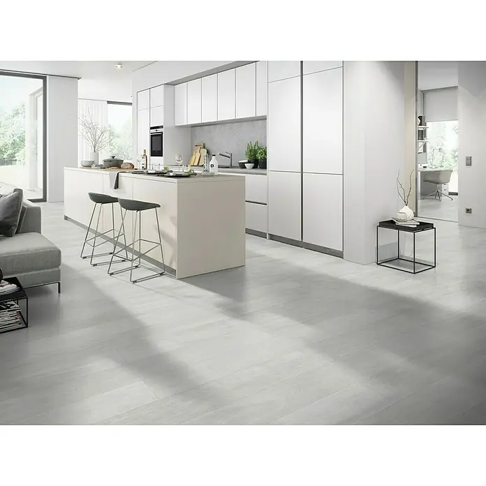 Classen Vinylbodenmuster GreenVinyl Pinie Weiß - 300 x 173 x 4 mm, Landhausdiele - Helle Holzböden in einer modernen, minimalistischen Küche. Das Design umfasst eine Kochinsel und schlichte weiße Schränke.