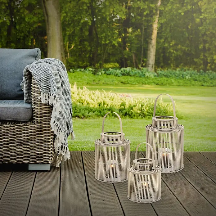 ECD Germany Windlicht Boho Bambus Laterne - Ø x H: 24,5 x 40,5 cm, Natur, 1 Stk. - Drei natürliche Bambuslaternen mit brennenden Kerzen auf einer Terrasse, neben einem Outdoor-Sofa im Garten.