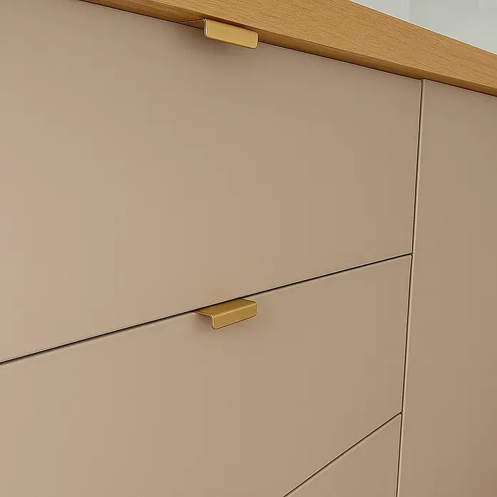 Cordia Möbelgriff 5 cm - Lochabstand: 24 mm, Aluminium, Gold - Hellbeige Küchenschubladen mit goldenen Messinggriffen und einer Holzarbeitsplatte.
