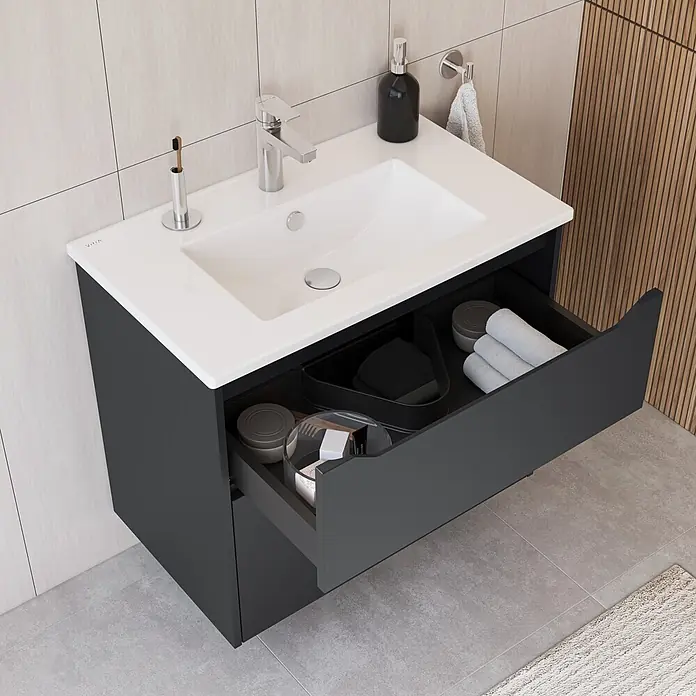 VitrA Integra Square Badmöbel-Set - Gesamtbreite Badmöbel: 80 cm, Graphit, Matt - Dunkelgrauer Badschrank mit weißem Waschbecken und offener Schublade, die organisierte Toilettenartikel und gerollte Handtücher zeigt.