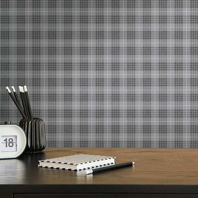 Profhome Vliestapete Vliestapete Grafisch, Geometrisch, Textiloptik, Kariert grau - staub-grau, 10.050 x 530 mm - Grau karierte Tapete an einer Wand über einem dunklen Holzschreibtisch mit Büromaterial.