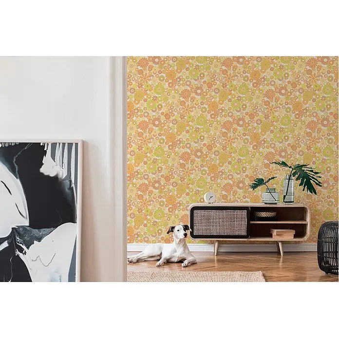 Profhome Vliestapete Heißgeprägte Vliestapete Blumen, Floral, Retro in gelb - creme-weißgrünocker-braun, 8.500 x 530 mm - Lebhafte Blumenmuster-Tapete in Orange-, Gelb- und Grüntönen an einer Raumwand, darunter Möbel und ein Hund.