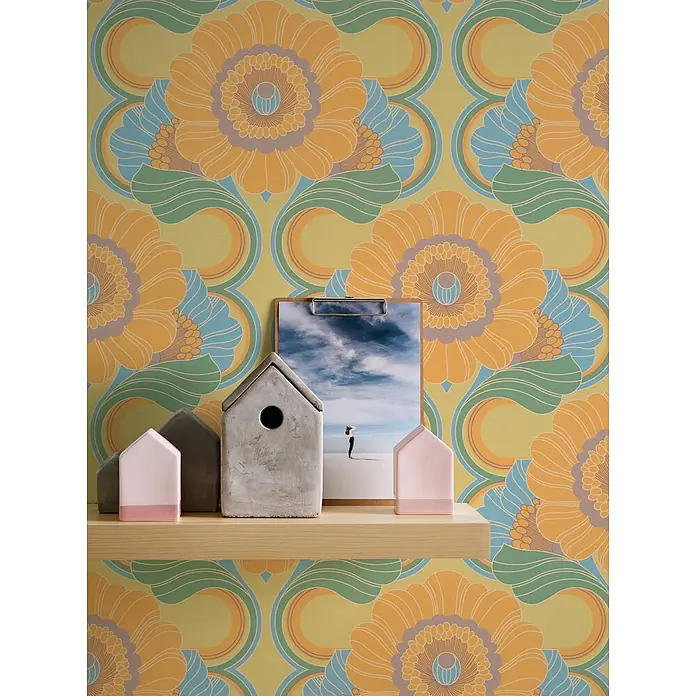 Profhome Vliestapete Heißgeprägte Vliestapete Blumen, Grafisch, Retro, Ornament in gelb - beige-graugrün, 8.500 x 530 mm - Set dekorativer Betonhäuser in Rosa und Grau, auf einem hellen Holzregal arrangiert.