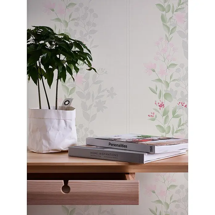 Profhome Vliestapete Vliestapete Floral in grün - graurosa, Floral, 10.050 x 530 mm - Blumenmuster-Tapete mit hellrosa Blüten und grünen Blättern, die einen Raum mit Pflanze und Büchern auf Holztisch schmückt.