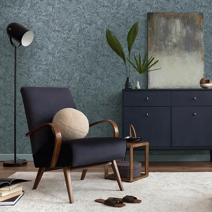 Profhome Vliestapete Heißgeprägte Vliestapete Ton-In-Ton, Floral, Textiloptik in blau - blau-grauplatin, 10.050 x 530 mm - Dunkelblauer Polstersessel mit Holzarmlehnen und -beinen, in gemütlichem Wohnzimmer arrangiert.