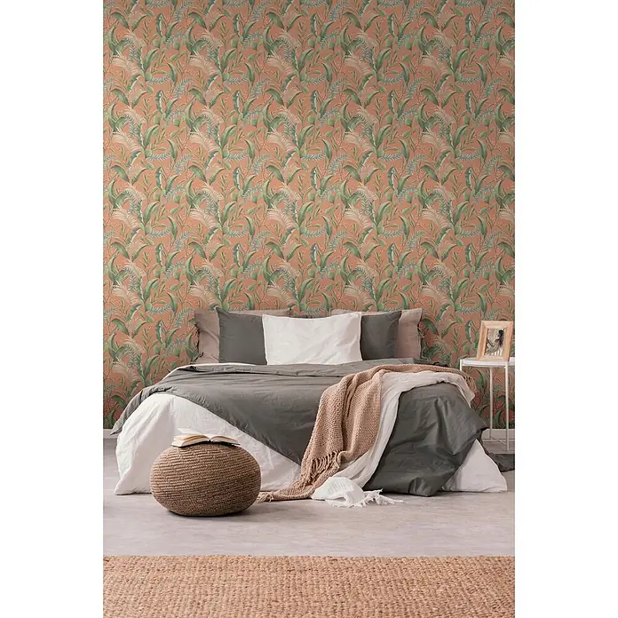 Profhome Vliestapete Vliestapete Blumen, Landhaus, Floral, Romantisch, Palmen, Natur in orange - beigegrünrot, 10.050 x 530 mm - Tapete mit tropischen Blättern auf orangem Hintergrund und grünen Blättern, bedeckt eine Schlafzimmerwand über einem Bett.