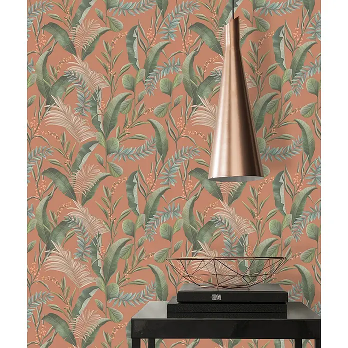 Profhome Vliestapete Vliestapete Blumen, Landhaus, Floral, Romantisch, Palmen, Natur in orange - beigegrünrot, 10.050 x 530 mm - Tropische Blatt-Tapete auf Terrakotta-Hintergrund, mit Kupferlampe und Tisch im Vordergrund.