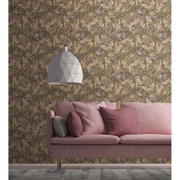Profhome Vliestapete Vliestapete Blumen, Floral, Dschungel, Natur, Exotisch in braun - beigelila, 10.050 x 530 mm - Gemusterte Tapete mit tropischen Blättern und Blüten in Braun, Grün, Lila und Blau, an einer Wand hinter einem pinken Sofa.