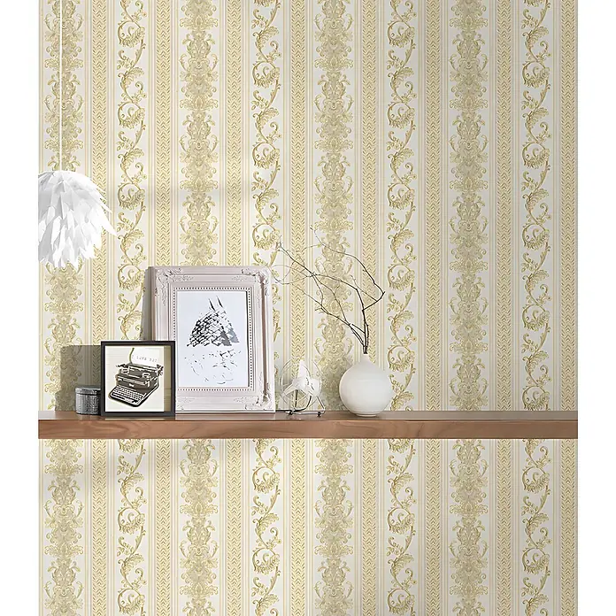 Profhome Vliestapete Vliestapete Streifen in gold - creme-weiß, Streifen, 10.050 x 530 mm - Cremefarbene und goldene gestreifte Tapete mit verschnörkelten Blumenmustern, an einer Wand hinter einem Holzregal.