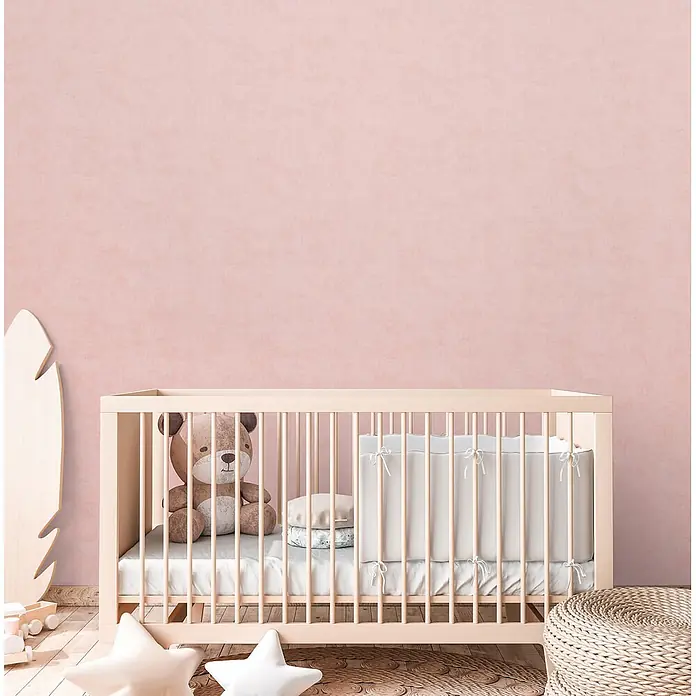 Profhome Vliestapete Vliestapete Kindertapete, Used Look, Textiloptik, Uni in rosa - lachs-rot, 10.050 x 530 mm - Helles Holzbettchen mit Teddybär und weißer Bettwäsche in einem Kinderzimmer.