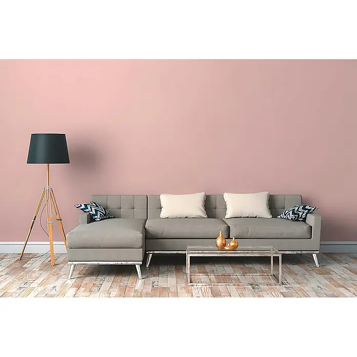 Profhome Vliestapete Vliestapete Uni in rosa - Uni, 10.050 x 530 mm - Graues Ecksofa mit weißen Kissen und Chrombeinen in einem modernen Wohnzimmer mit rosa Wand.