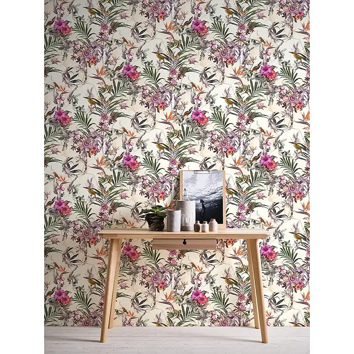 Profhome Vliestapete Glatte Vliestapete ohne Struktur Blumen, Kolibri, Floral in creme - beigegrünrosa, 10.050 x 530 mm - Tropische Blumentapete mit rosa Blüten, grünen Blättern, Vögeln und geometrischen Umrissen, hinter einem Holztisch.