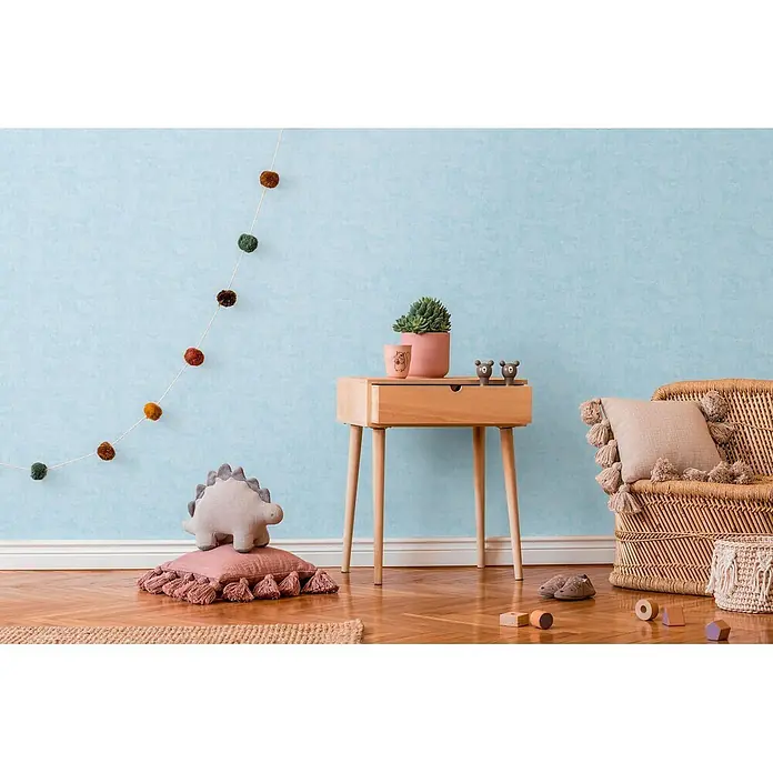Profhome Vliestapete Vliestapete Kindertapete, Used Look, Textiloptik, Uni in blau - blau-grünhell-blau, 10.050 x 530 mm - Heller Nachttisch aus Holz mit Schublade, dekoriert mit Sukkulente und Bärenfiguren, in einem verspielten Kinderzimmer.