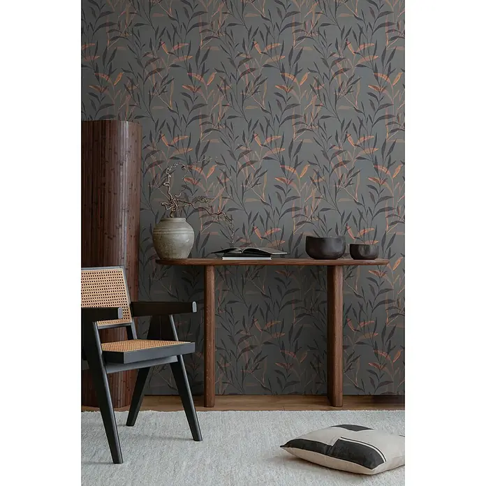 Profhome Vliestapete Heißgeprägte Vliestapete Landhaus, Floral, Natur in anthrazit - grau-braunlilaorange-rot, 10.050 x 530 mm - Dunkelgrüne Tapete mit wiederholtem Muster aus dunkel- und brenn-orangefarbenen Blättern, in einem eleganten Raum mit Holzmöbeln.