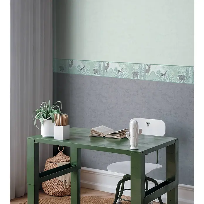 Profhome Vliestapete Vliestapete Kindertapete, Used Look, Textiloptik, Uni grau - hell-grün, 10.050 x 530 mm - Grüne Tapetenbordüre mit verspieltem Waldtiermotiv, die den oberen Teil einer Wand über einem Schreibtisch schmückt.