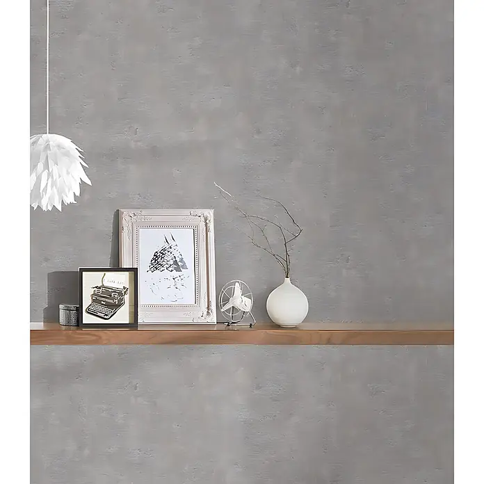 Profhome Vliestapete Vliestapete Uni grau - Uni, 10.050 x 530 mm - Strukturierte graue Wand mit Holzregal, Dekoartikeln und weißer Hängeleuchte.