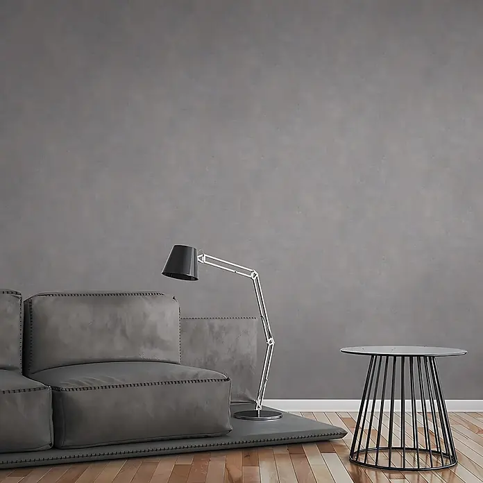 Profhome Vliestapete Vliestapete Uni grau - Uni, 10.050 x 530 mm - Ein modernes Wohnzimmer mit einem modularen Sofa in Grau, einer stilvollen schwarzen Stehlampe und einem runden Beistelltisch mit schwarzem Lattenfuß.
