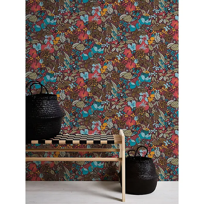 Profhome Vliestapete Vliestapete Dschungel in rot - beigegelb, 10.050 x 530 mm - Lebhafte Blumentapete mit roten, blauen, gelben und grünen Blumen auf bordeauxrotem Hintergrund, ergänzt durch Holzbank und schwarze Körbe.