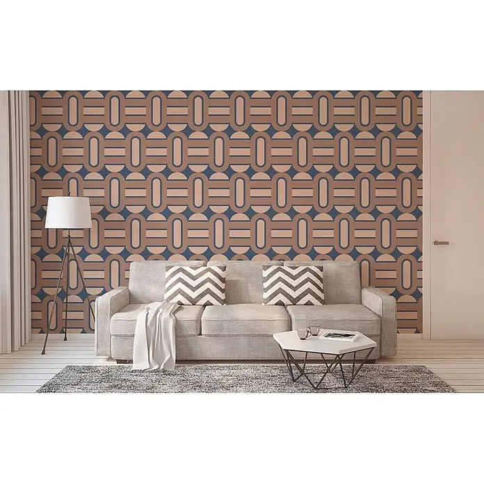 Profhome Vliestapete Heißgeprägte Vliestapete Grafisch, Retro, Geometrisch, Ornament in blau - blass-braunbraun-beige, 8.500 x 530 mm - Geometrische braun-blaue Mustertapete an einer Wohnzimmerwand hinter einem grauen Sofa. Retro-Design mit verbundenen Formen.