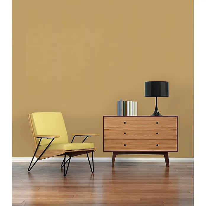 Profhome Vliestapete Vliestapete Uni in gelb - Uni, 10.050 x 530 mm - Gelber Sessel und Holzkommode mit schwarzer Lampe und Büchern in einem modernen Raum.