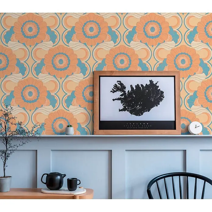 Profhome Vliestapete Heißgeprägte Vliestapete Blumen, Grafisch, Retro, Ornament beige - lachs-orangepastell-gelb, 8.500 x 530 mm - Retrotapete mit orangefarbenen, blauen und cremefarbenen Blumen auf pfirsichfarbenem Hintergrund, an einer Wand angebracht.