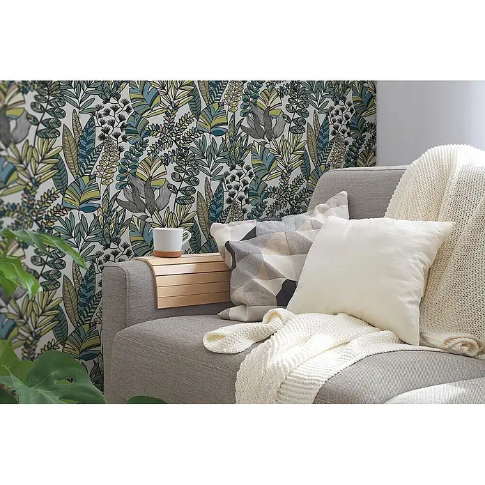 Profhome Vliestapete Heißgeprägte Vliestapete Floral, Grafisch, Retro in weiß - blauoliv-grünschwarz, 10.050 x 530 mm - Helles Holz-Sofa-Armlehntablett mit Lamellen, hält eine weiße Tasse auf einem grauen Sofa.