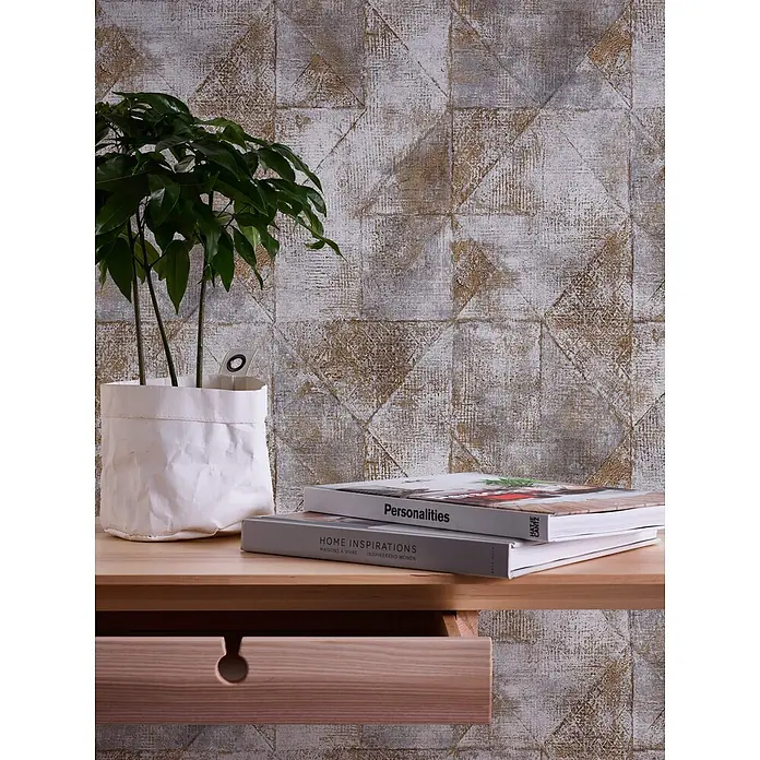 Profhome Vliestapete Vliestapete Geometrisch, Used Look, Spachteloptik, Rauten Muster in gold - grau, 10.050 x 530 mm - Holzregal mit geöffneter Schublade und markantem Rundgriff, dekoriert mit Pflanze und Büchern.