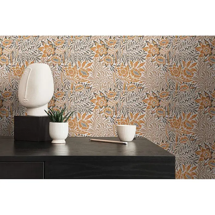 Profhome Vliestapete Vliestapete Blumen, Landhaus, Floral, Retro in orange - beige-braunschwarz, 10.050 x 530 mm - Florale Tapete mit orangefarbenen, braunen und grauen Mustern, stilisiert hinter einem dunklen Schreibtisch mit Dekoration.
