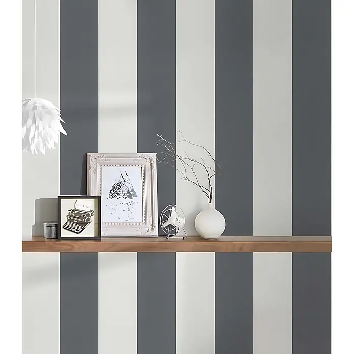 Profhome Vliestapete Vliestapete Traditionell grau - 10.050 x 530 mm - Grau-weiß gestreifte Tapete an einer Wand, mit Holzregal und Dekoration.