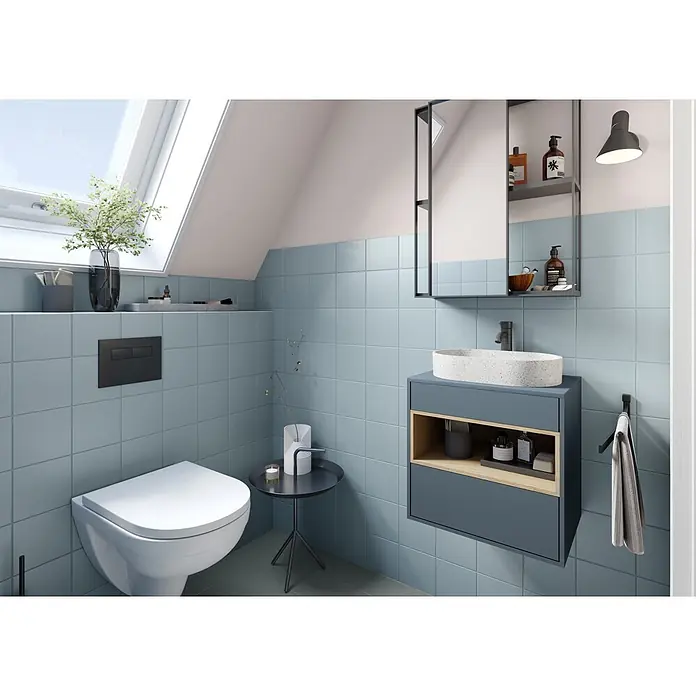 Alpina Wandfarbe Bad & Küche Magnolie - Beige, Matt, 2,5 l - Modernes Bad mit blauen Fliesen, wandhängendem WC, dunkelgrauem Waschtisch mit weißem Waschbecken und Spiegelschrank.