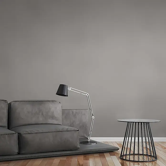 Profhome Vliestapete Vliestapete Uni grau - Uni, 10.050 x 530 mm - Graues Modulsofa, schwarze verstellbare Stehlampe und schwarzer Metallbeistelltisch in modernem Wohnzimmer.