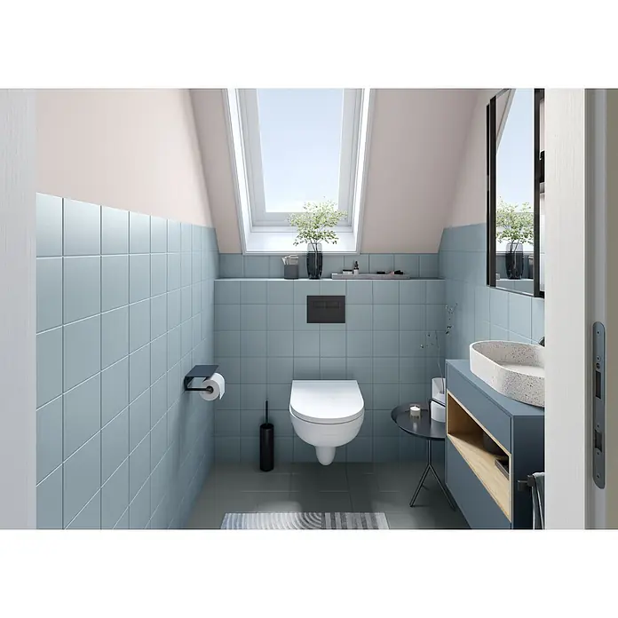 Alpina Wandfarbe Bad & Küche Magnolie - Beige, Matt, 2,5 l - Modernes Badezimmer mit hellblauen Fliesenwänden, wandhängender weißer Toilette und einem Waschtisch mit ovalem gesprenkeltem Waschbecken.