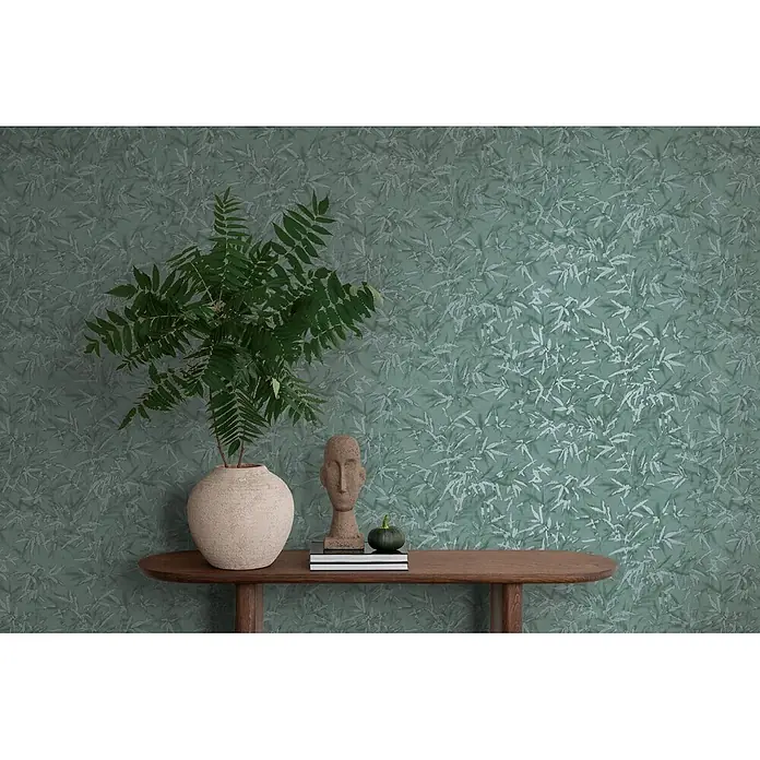 Profhome Vliestapete Heißgeprägte Vliestapete Ton-In-Ton, Floral, Textiloptik in grün - patina-grünplatin, 10.050 x 530 mm - Grüne Tapete mit hellem Blattmuster, die einen Raum mit Konsole und Pflanzen akzentuiert.