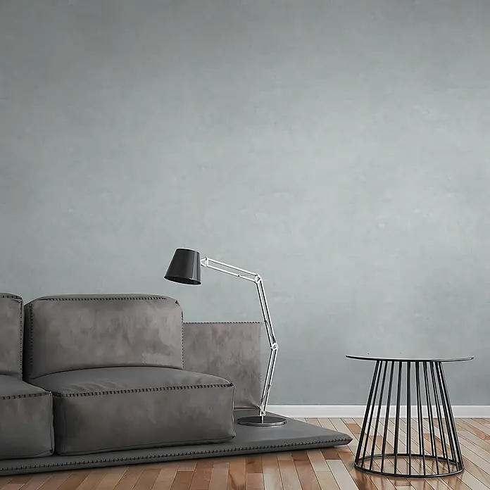 Profhome Vliestapete Vliestapete Uni grau - Uni, 10.050 x 530 mm - Modernes Wohnzimmer mit grauem Modulsofa, schwarzer Stehlampe und schwarzem Drahtbeistelltisch.