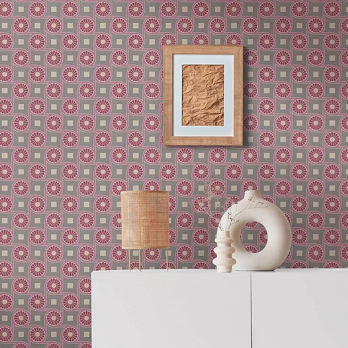 Profhome Vliestapete Vliestapete Grafisch, Retro, Geometrisch, Ornament, Design grau - beige-graulila, 10.050 x 530 mm - Rosa-graue geometrische Tapete mit Blumenmuster hinter einem Holzbilderrahmen und weißen Möbeln.