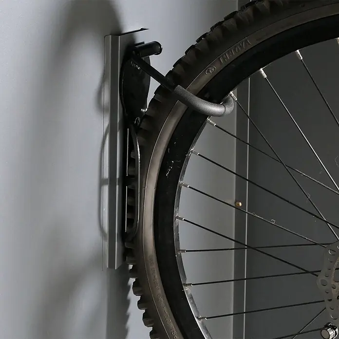 Proregal Fahrradgarage 2er abschließbar - 125 x 158 x 213 cm, Grau - Silber-graue Wandfahrradhalterung, die ein schwarzes Fahrradrad hält.