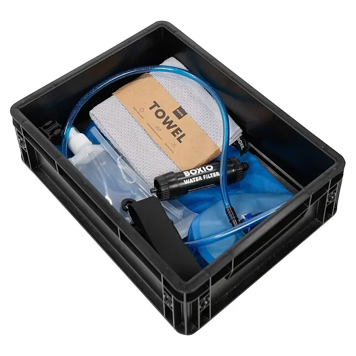 Boxio Campingwaschbecken Wash Max+ - 40 x 30 x 40 cm, 5 -tlg. - Schwarze BOXIO Kunststoffkiste mit grauem Handtuch, blauem Wasserfiltersystem mit Schlauch und schwarzem Gurt.