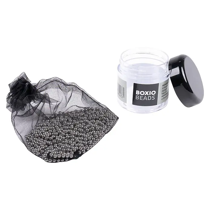 Boxio Reinigungsperlen Beads - Edelstahl - Kleine silberne Perlen in einem schwarzen Netzbeutel neben einem transparenten Glas mit schwarzem Deckel und der Aufschrift BOXIO BEADS.