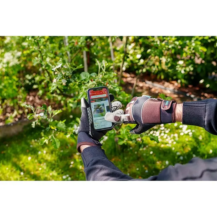 Gardol Gartenhandschuhe für den Geräteeinsatz - 8, M, Braun - Hände in Gardol Gartenhandschuhen blättern draußen im Garten auf einem Smartphone.