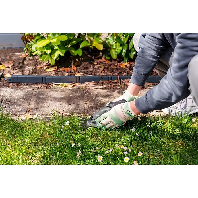 Gardol Gartenhandschuhe für den Geräteeinsatz - 8, M, Mint - Eine Person in hellgrünen Handschuhen trimmt mit einer grauen Hand-Grasschere Rasenkanten, umgeben von grünem Gras und Gänseblümchen.