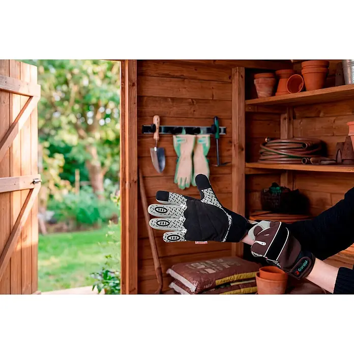 Gardol Gartenhandschuhe für den Geräteeinsatz - 8, M, Braun - Person trägt Gardol Gartenhandschuhe (schwarz, grau, braun mit gemustertem Griff) in einem Gartenschuppen, bereit für die Arbeit.