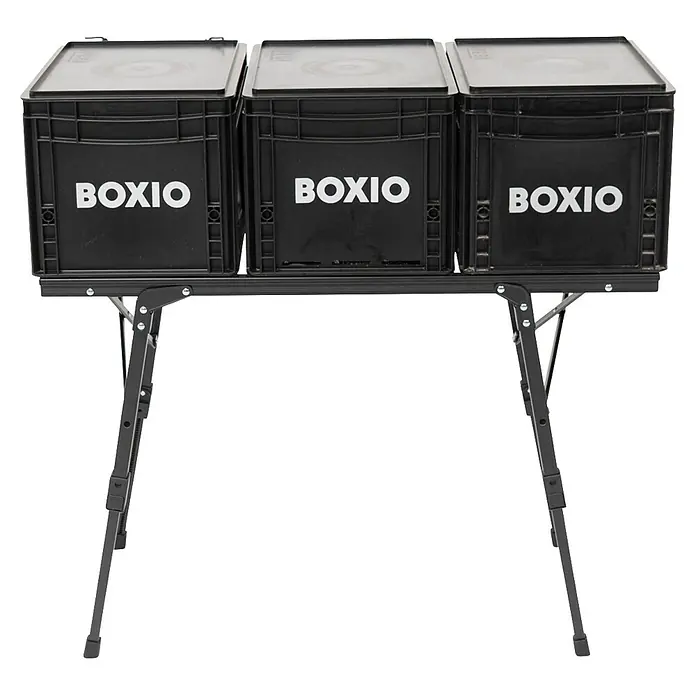 Boxio Campingtisch - L x B x H: 90 x 21 x 11,5 cm, Aluminium - Drei schwarze BOXIO Aufbewahrungsboxen auf einem schwarzen tragbaren Klapptisch.