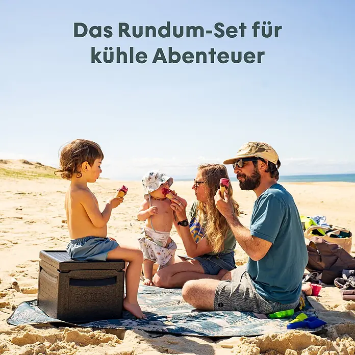 Boxio Kühlbox Cool Plus - Schwarz, 16 l, 3 -tlg. - Eine schwarze Kühlbox dient einem Kind am sonnigen Strand als Sitzgelegenheit, während die Familie Eis genießt.