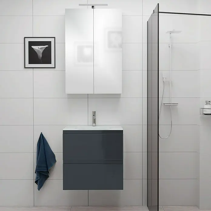 Camargue Espacio Badmöbel-Set E24 - 60 cm, Gama anthrazit glänzend - Ein elegantes Badezimmer-Setup mit einem grauen Waschtischunterschrank und einem weißen Spiegelschrank, abgerundet durch eine moderne Duschkabine.