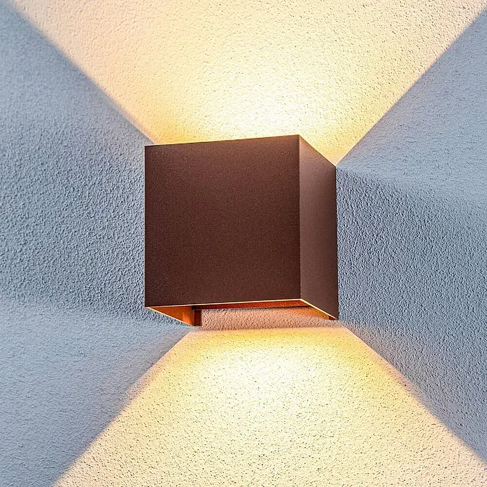 Lindby Außenwandleuchte Nivar - braun / rost, IP54 - Dunkelbraune quadratische Wandleuchte, die Licht nach oben und unten auf eine strukturierte Wand wirft.